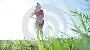 Girl wind nature. The girl is standing in the field of green grass. Woman freedom lifestyle