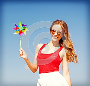 Girl with windmill toy on the beach