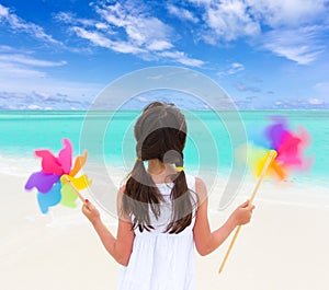 Girl with windmills on beach