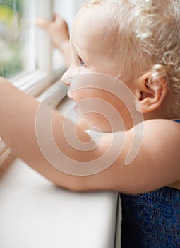 Girl, window and baby with smile standing against glass or wall in family home learning to walk. Happy, female toddler