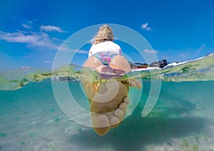 Girl windsurfer on a board in tropical clear water