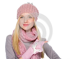 Girl in winter clothes pointing on copy space