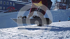 A girl in winter clothes and ski clothes puts a snowboard on her feet. Fastens the clasps. Getting ready to ride on the
