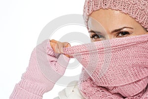 Girl in winter clothing closing face with scarf