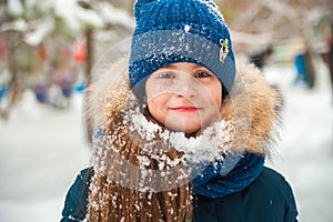 Girl in the winter forest close-up and copy space. A child plays in the winter with snow