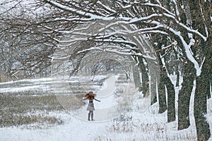 Girl in the winter forest dancing, it is snowing