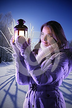 Girl on winter snow with christmas lantern