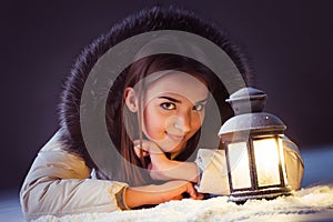 Girl on winter snow with lantern