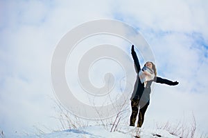 Girl in winter stands on a hill with his hands up. concept of freedom or victory