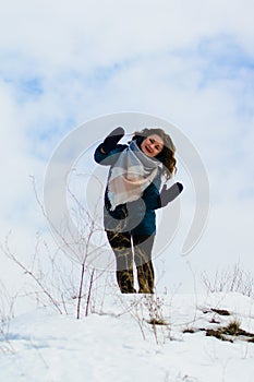 Girl in winter stands on a hill with his hands up. concept of freedom or victory