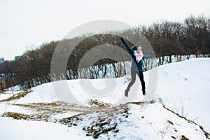 Girl in winter stands on a hill with his hands up. concept of freedom or victory