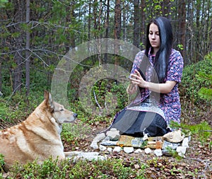 Girl witch conjures in the woods. Near a huge dog