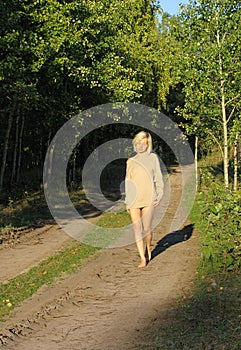 Girl wolking along the forest roud