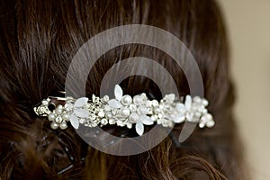 Girl or woman with dark hair with wedding hairstyle of barrette with rhinestones