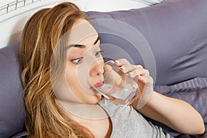 Girl woman drink water in bed at home, healthcare concept, hangover