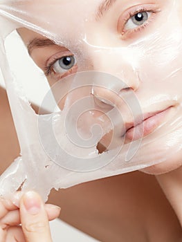 Girl woman in facial peel off mask. Skin care.