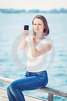 Girl woman looking at cell phone making selfie