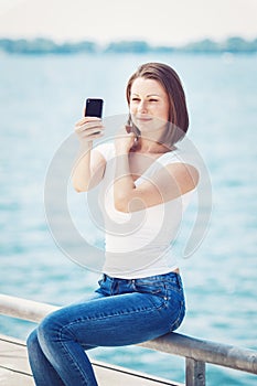 Girl woman looking at cell phone making selfie