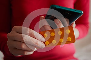 The girl woman uses a smartphone to buy medics online. Shopping at an online store.