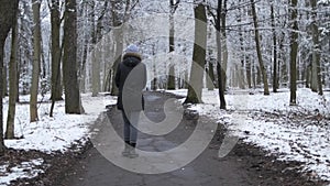 Girl, woman walking in the forest, park in cloudy spring weather.