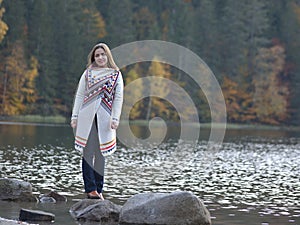 Girl on the wooden jetty at a lake in autumn season