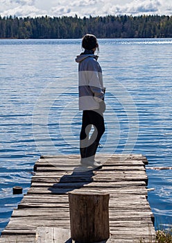 Girl on a wooden pier by the lake
