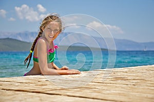 Girl by the wooden pier in the sea