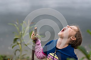 Girl with a wooden stick screaming loudly