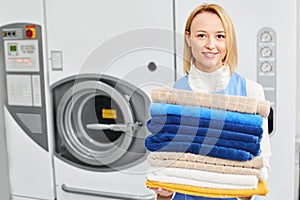 Girl worker holding a Laundry service clean towels