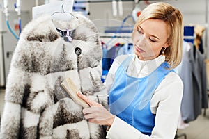 Girl worker performs dry Laundry, hand cleaning fur garments