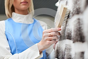 Girl worker performs dry Laundry, hand cleaning fur garments