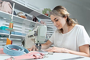Girl worker sews on a sewing machine