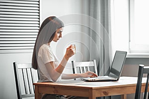 Girl working on computer laptop in light room