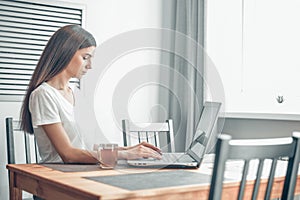 Girl working on computer laptop in light room