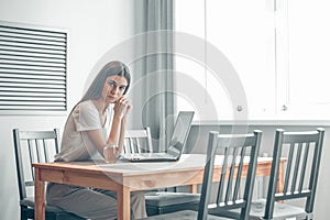 Girl working on computer laptop in light room