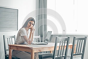 Girl working on computer laptop in light room