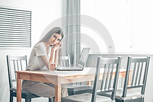 Girl working on computer laptop in light room