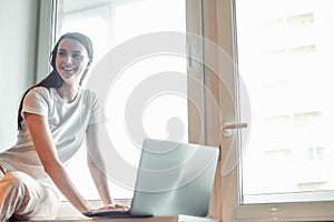 Girl working on computer laptop in light room