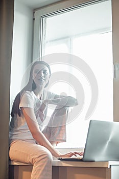 Girl working on computer laptop in light room