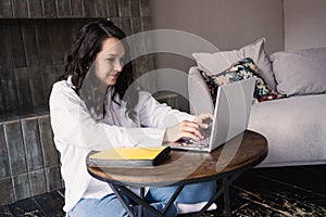 Girl working on laptop from home or student studying from home or freelancer. Online work, early in the morning desk