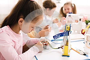 Girl working with wires and circuits on robotics project