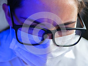 The girl works in the DNA laboratory. A young female technician or scientist works in a laboratory. Close-up