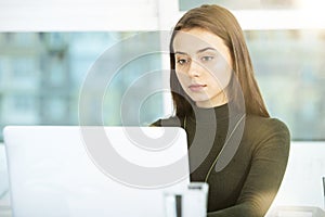 Girl works on a laptop in office