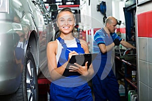 Girl in workwear in auto mechanic workshop