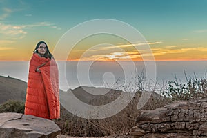 Girl Wrapped in Blanket while watching sunset