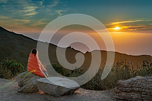 Girl Wrapped in Blanket while watching sunset