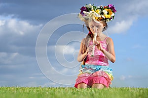 Girl with a wreath of flowers on her head playing