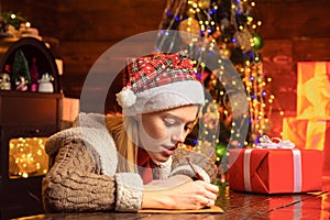 Girl write letter to Santa. Santa Claus mood. Young woman with wishlist for Santa.