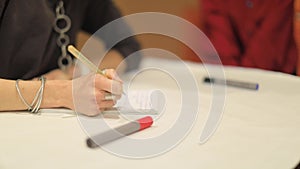 Girl writes at the event with a pencil marker on a sheet