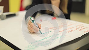 Girl writes at the event with a pencil marker on a sheet